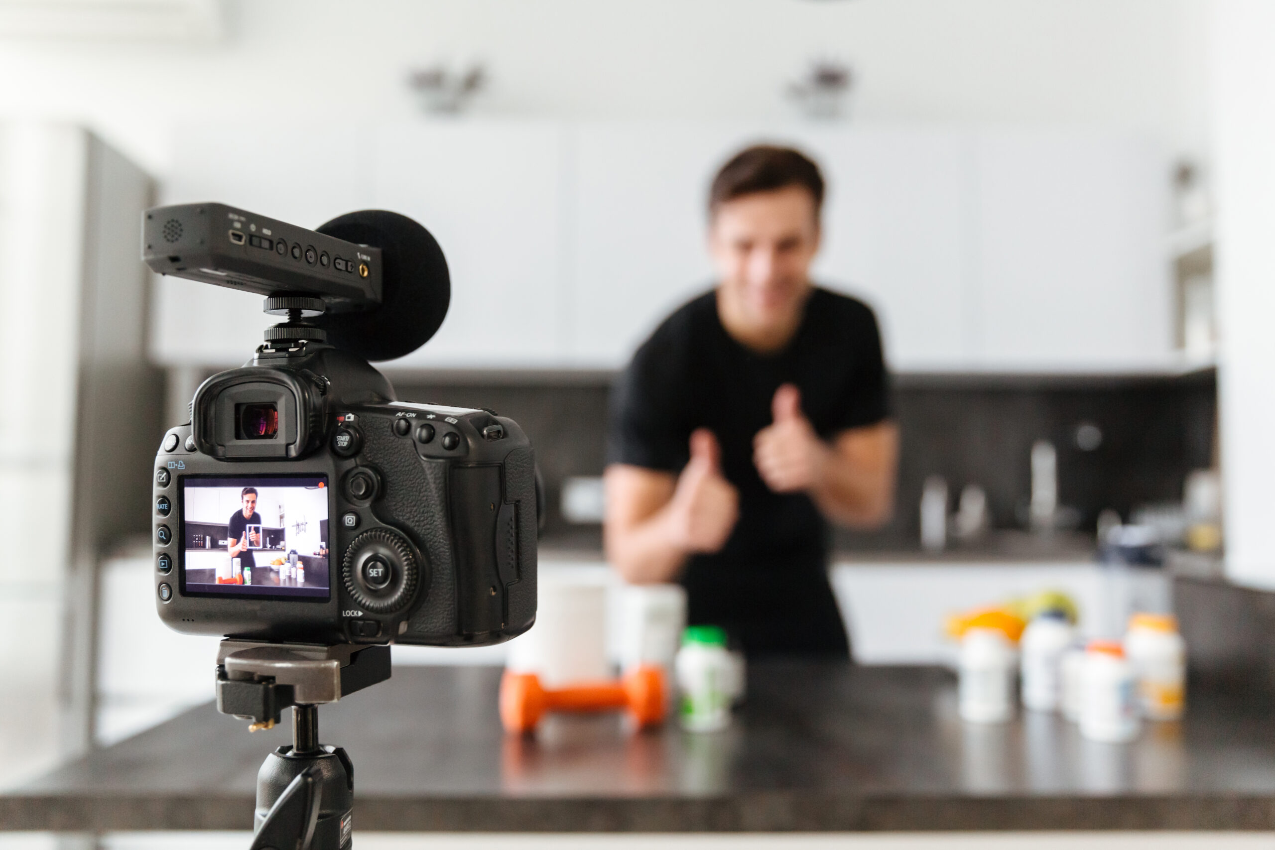 Smiling young man filming his video blog episode Image of a male filming his fitness routine