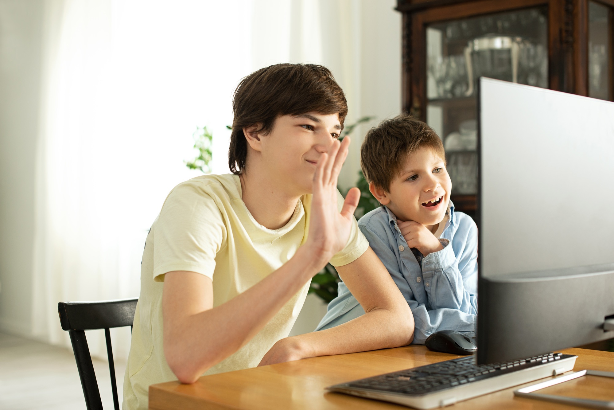 smiling-boy-teenager-chatting-online-waving-computer-screen2